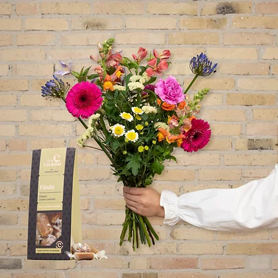 Send en smuk vild multifarvet buket med flødekarameller samt gerbera, nelliker