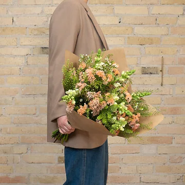 Smuk vild marketbuket i peach farver med hindebæger, løvemunde og voksblomster