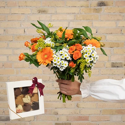 Send en smuk tætbundet forårsbuket med chokoladehjerter, gerbera og roser