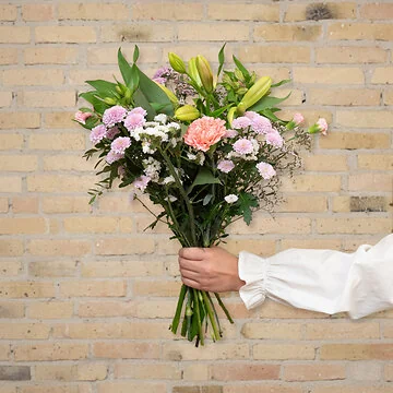 Send en smuk pastel blomsterbuket, der holder længere med liljer og nelliker